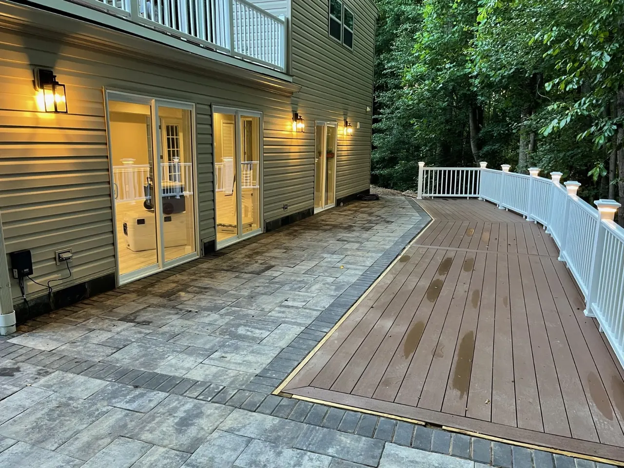 Deck + paver patio at dusk — Eagle Home Improvements